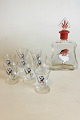 Christmas carafe with 8 small glasses. Decorated with Santa Claus. The Carafe is 
spherical grinded at the bottom and labeled "6". A glass with chip