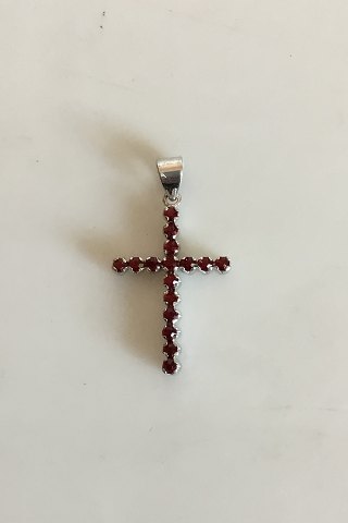Pendant in 18 K. White gold shaped like cross with 16 red stones