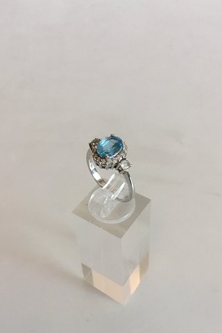 Ring in 14K White Gold with Blue Stone (Safire) Two Brilliants surrounded by 16 
small stones.