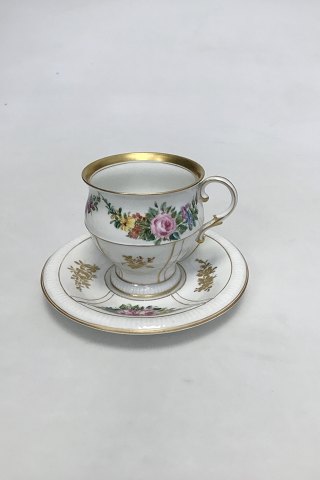 Bing & Grøndahl Cup and Saucer in gilt and Polychrome over glaze with floral 
motive.