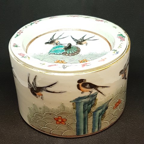 Chinese lidded jar in porcelain. Decorated with birds. Lid with a leaf in silver 
and cloisonne, that is used as a handle.